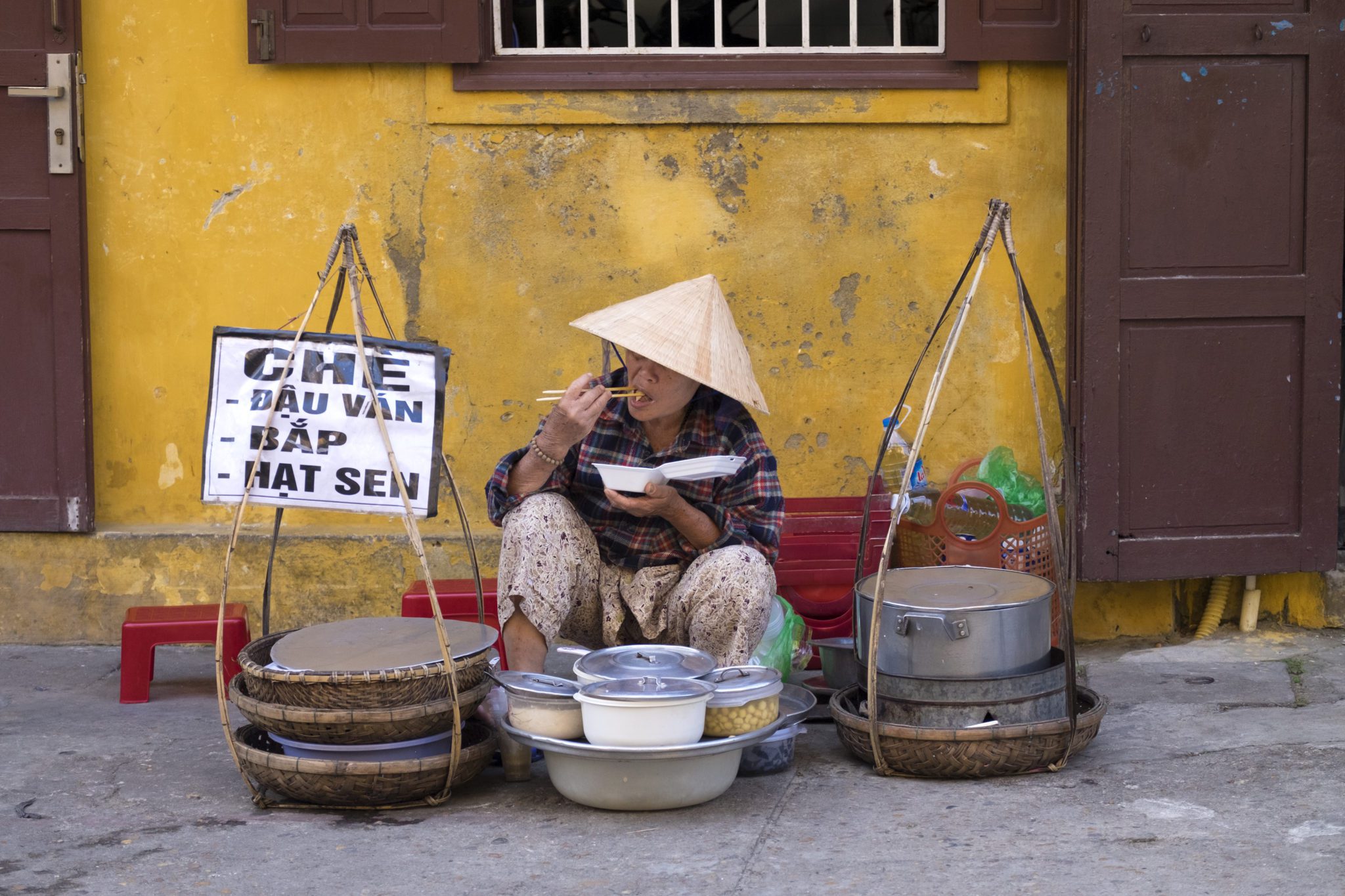 A street vendor eating her lunch in the old quarter of Hoi An, Vietnam