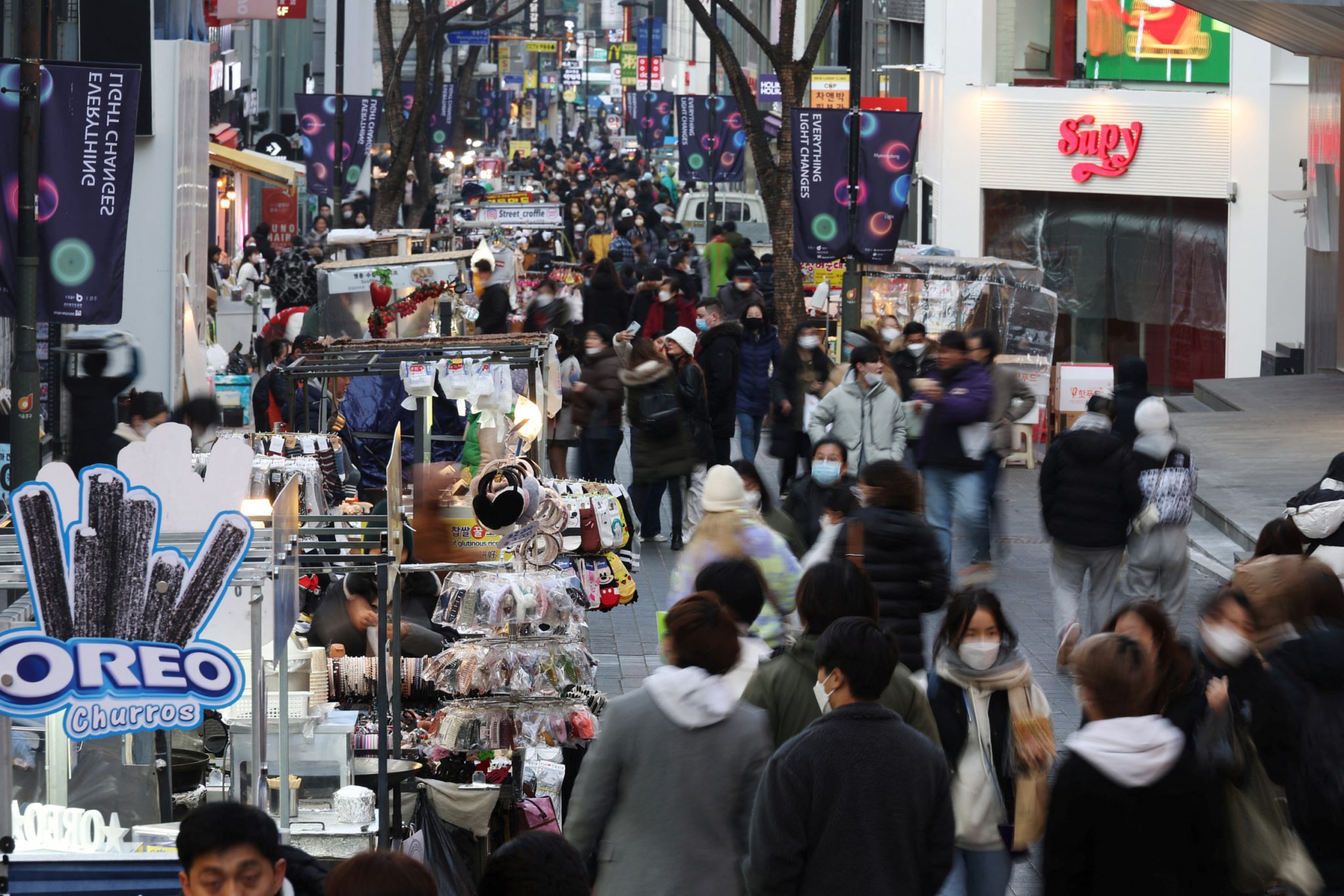 Street vendors (L) wait for customers at Myeongdong shopping district in Seoul, South Korea. Source: Reuters/Kim Hong-Ji