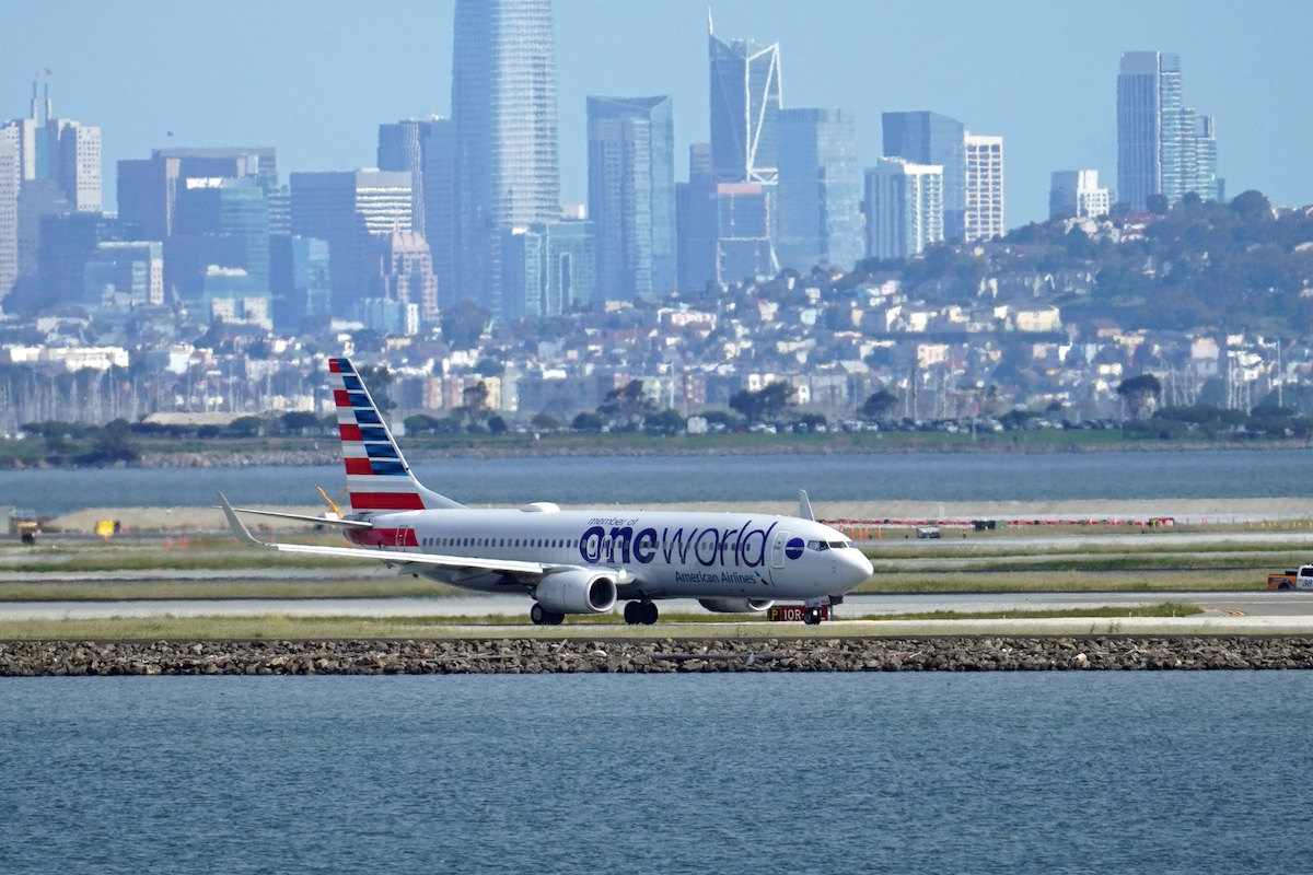 An American plane taxis with the San Francisco skyline in the background. (Luke Lai/Flickr)