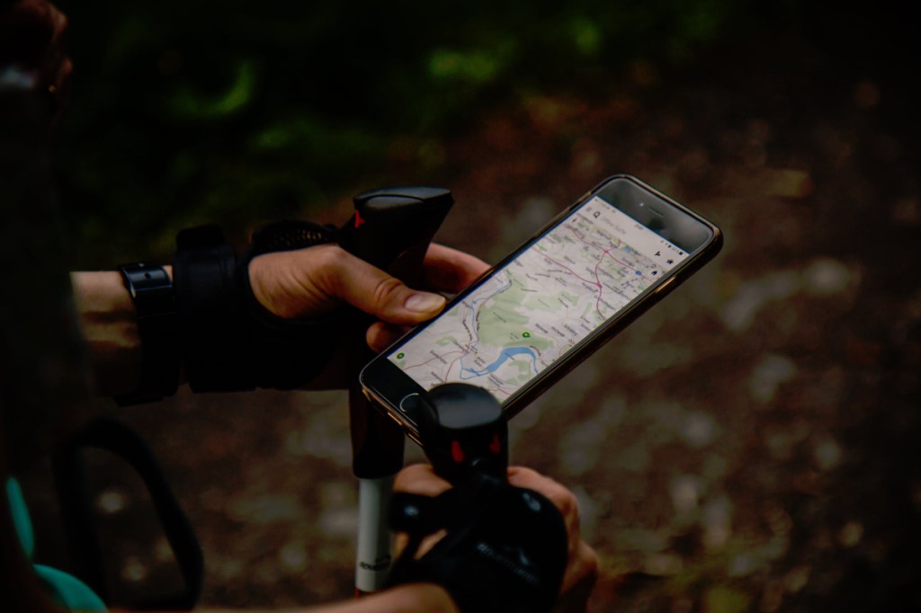 A traveler looking at an app while walking in a forest