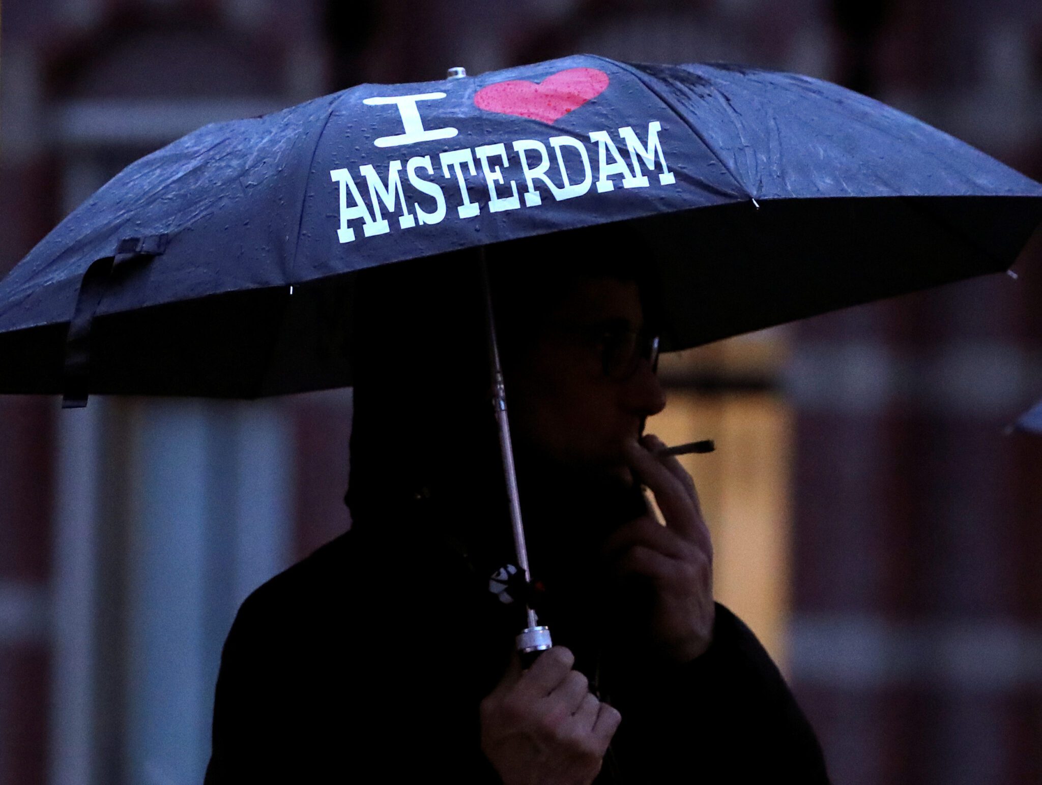 Man smoking in the Amsterdam rain. 