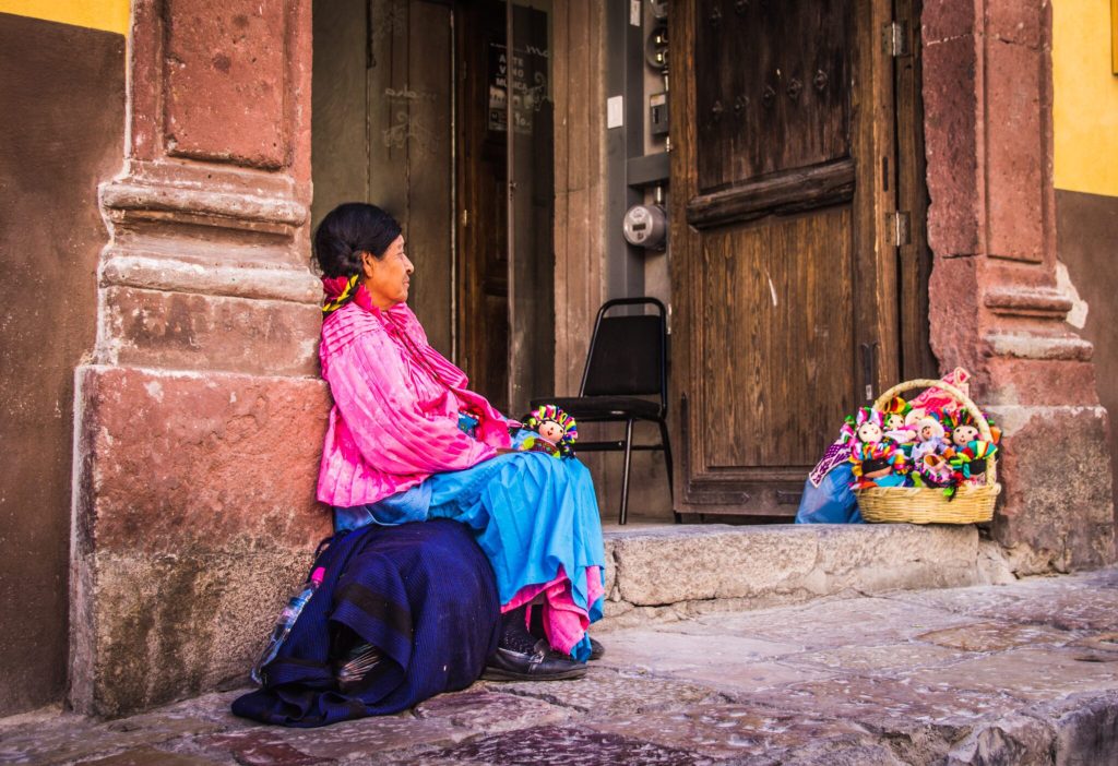 Indigenous Mexican woman selling dolls. Source: Unsplash