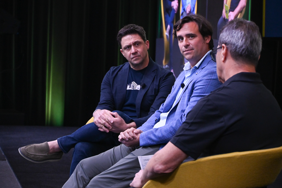 Rob Greyber, CEO of Vacasa (left), and Tim Rosolio, vice president of vacation rental partner success at Expedia Group, joined a panel moderated by Dennis Schaal. 