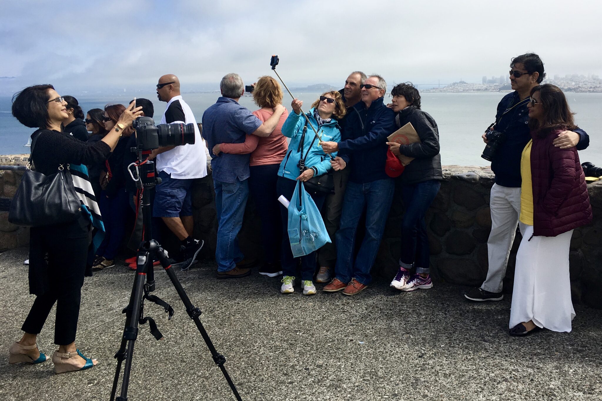 Tourists posing for photos near Golden Gate Bridge in San Francisco, California.