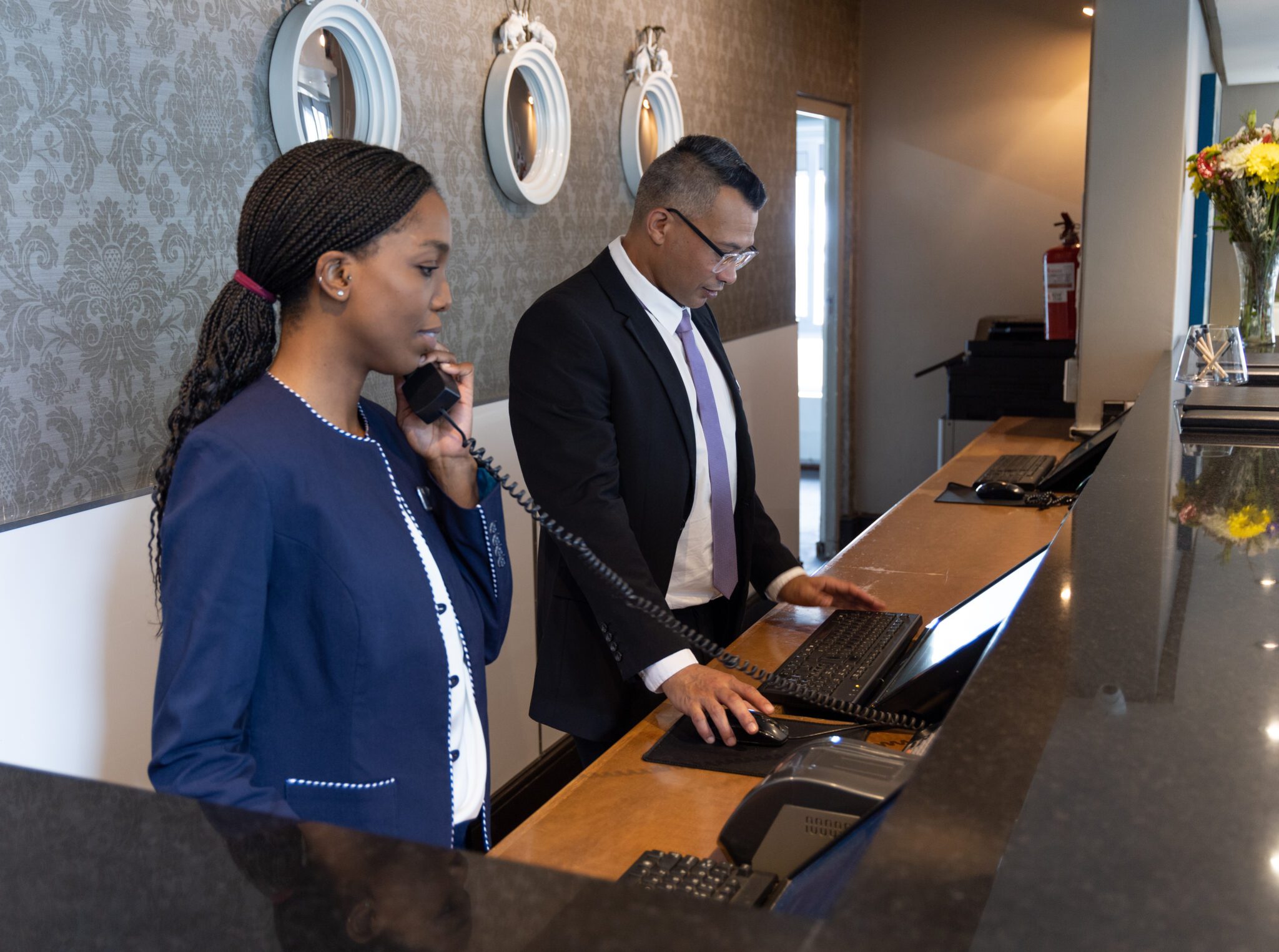 Hotel workers at a reception desk. The latest U.S. jobs report revealed hotels added jobs.  
