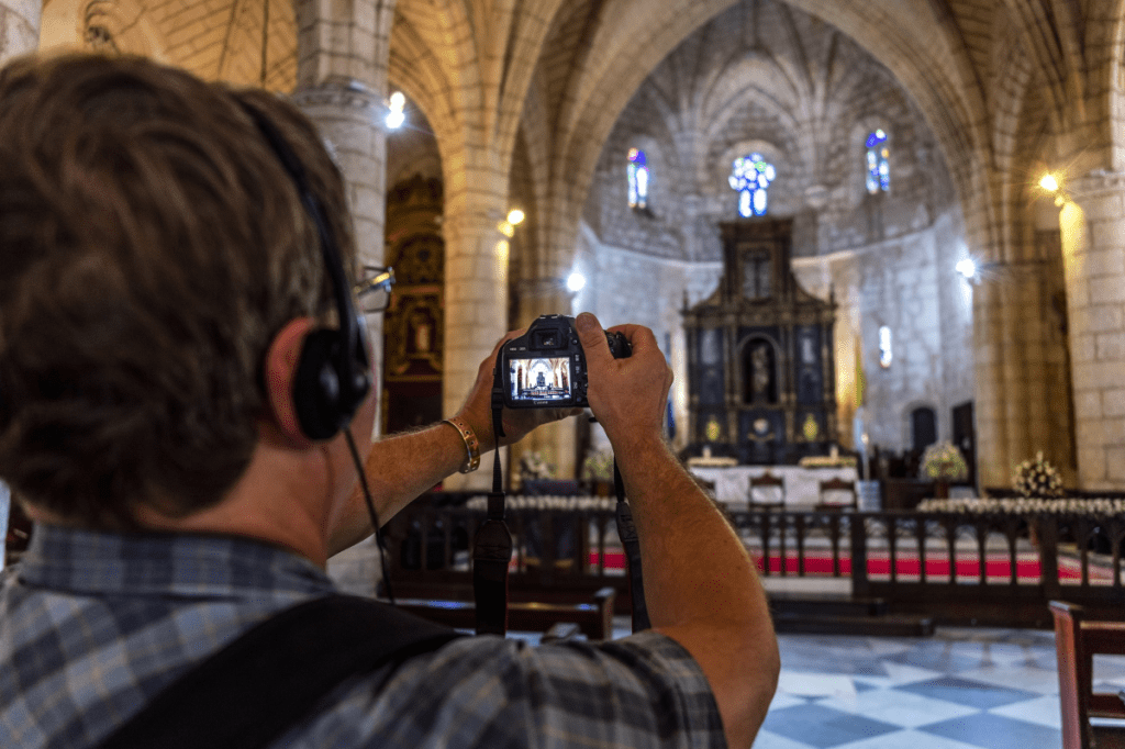 A tourist takes a picture during a tour.