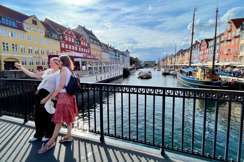 A couple posing for a photograph along a canal in Copenhagen