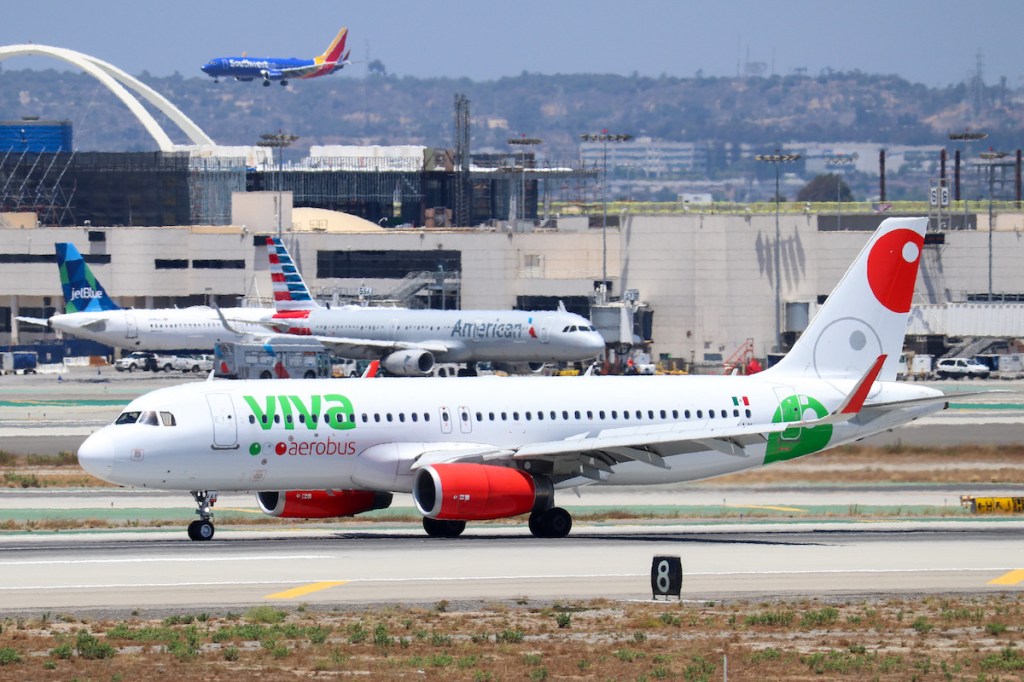 Viva Aerobus plane taxis past American and JetBlue aircraft at LAX