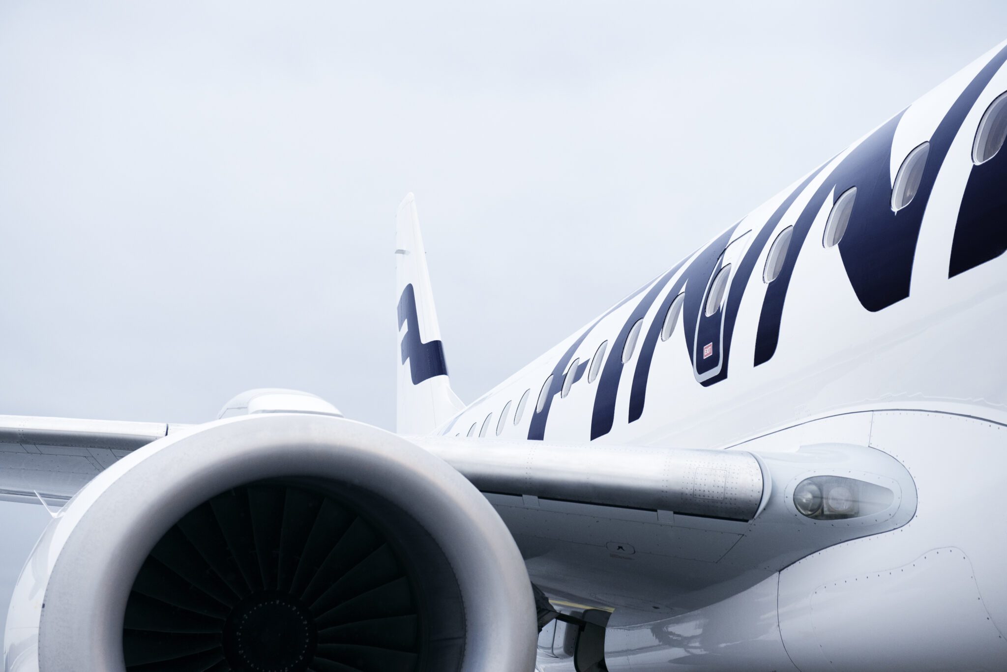 The side, wing and engine of a Finnair Embraer aircraft.
