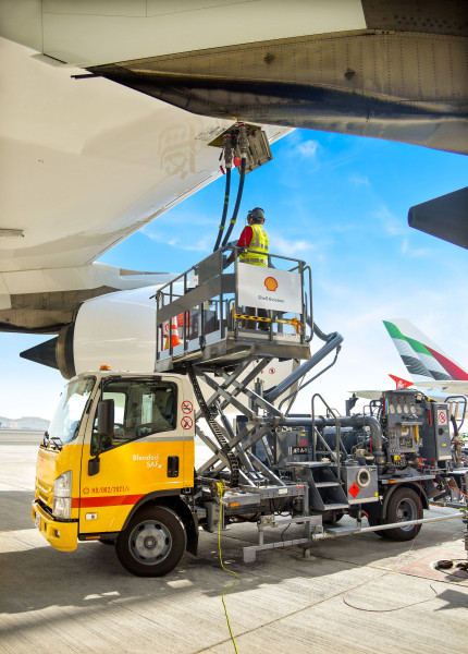 An Emirates employee re-fuelling an aircraft using sustainable aviation fuel.