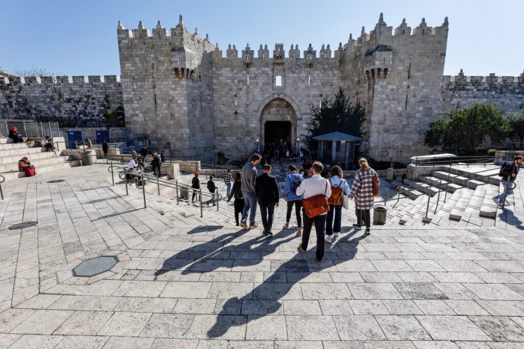 A group of tourists descends the stairs leading to the Damascus Gate in Jerusalems Old City