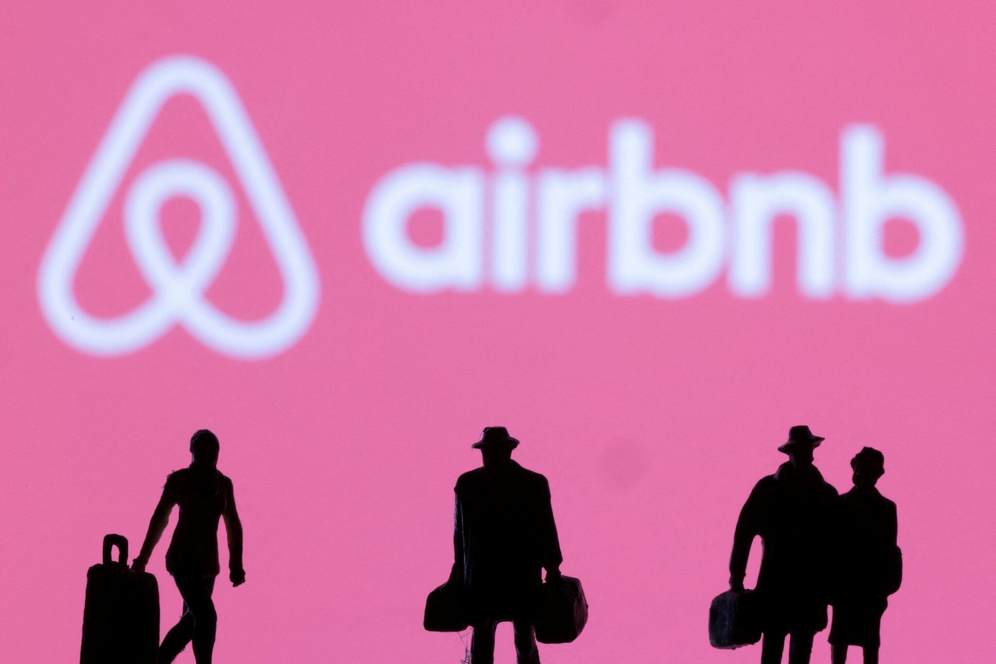 Figurines are seen in front of the Airbnb logo in this illustration taken February 27, 2022. Illustration by Dado Ruvic. Source: Reuters.