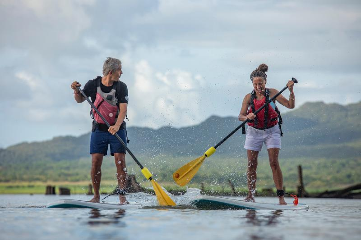 Couple paddle boarding in La Fortuna, Costa Rica on a Geluxe Collection tour. 