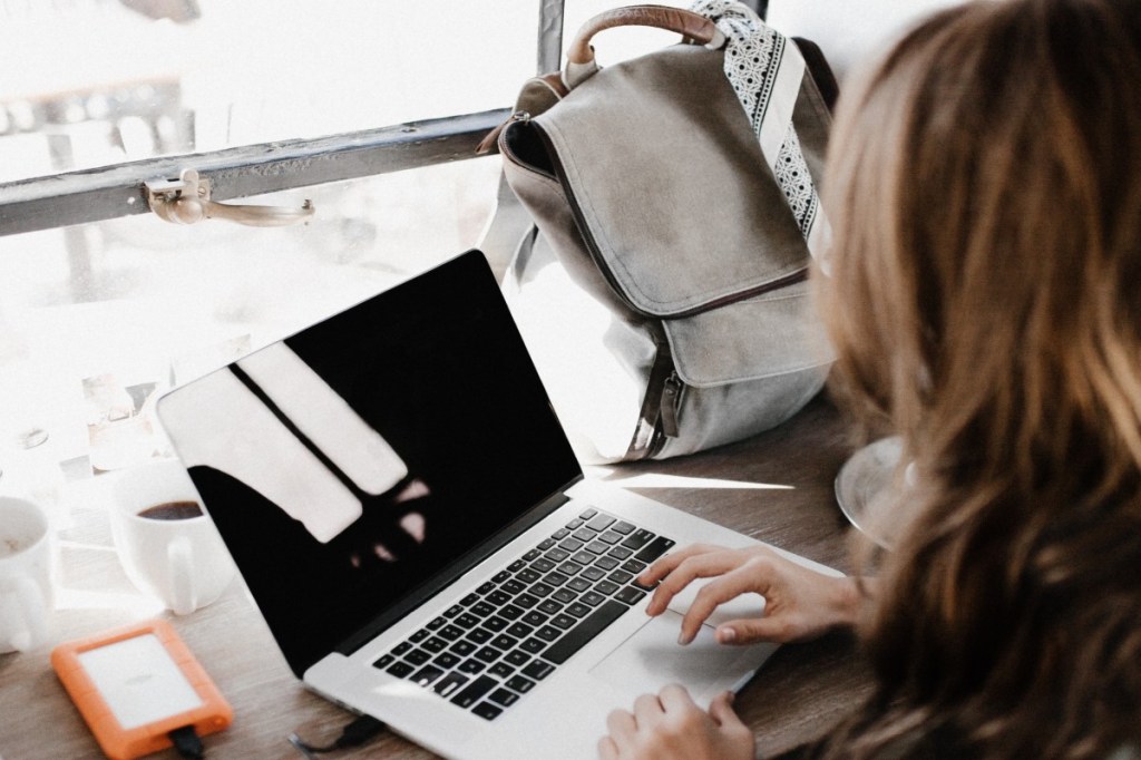 A woman traveler working at laptop.