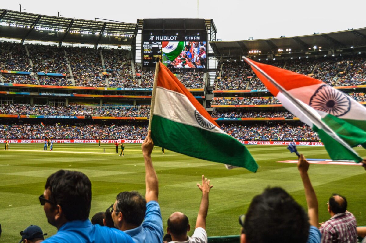 Indian fans cheer at a cricket match. 