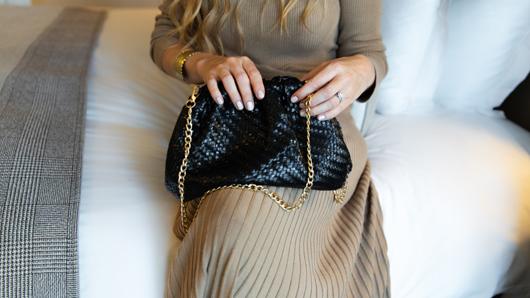 A guest holding an Anthropolgie bag in a Kimpton Hotel room.
