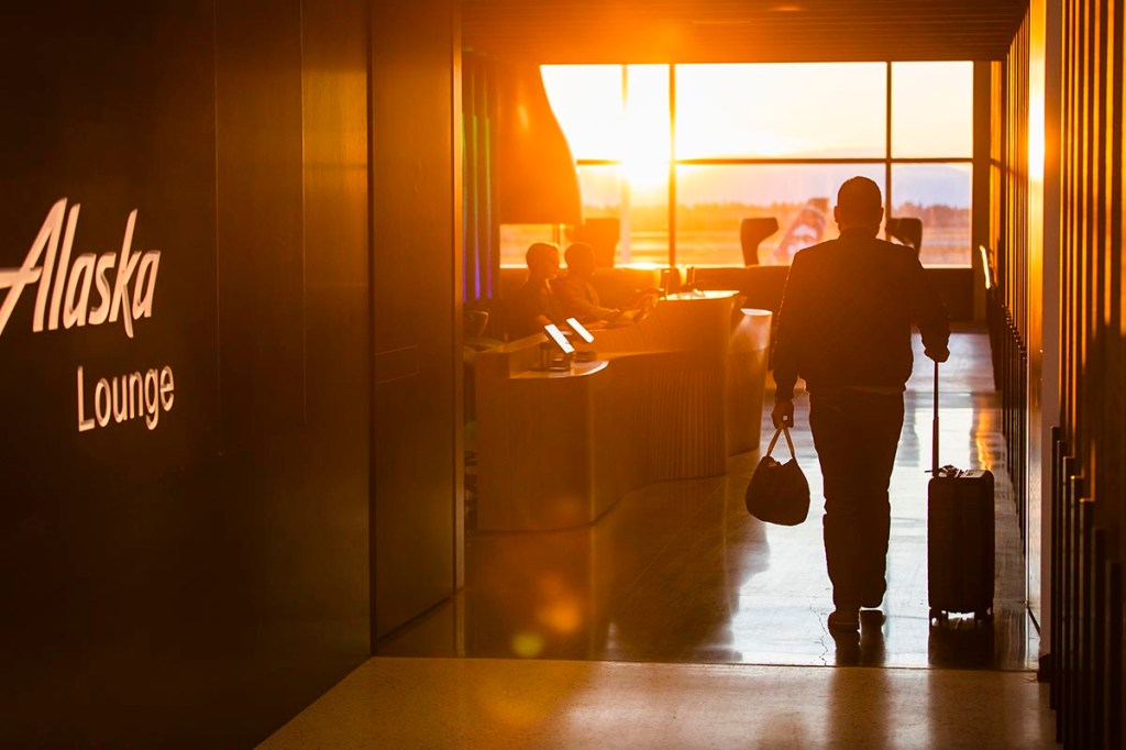 silhouette of a man walking into an airport lounge with sunlight