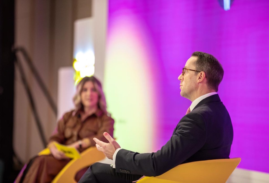 Two people on stage in a panel discussion