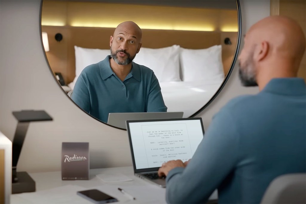 Actor Keegan-Michael Key at a desk in a commercial