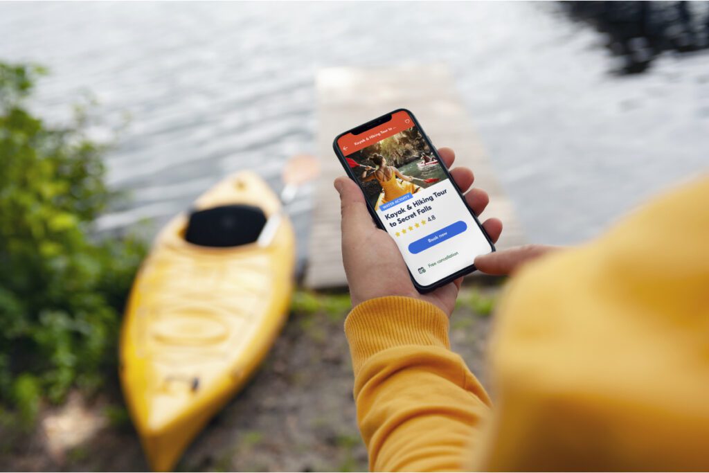 view of person using GetYourGuide booking app for a kayaking trip source getyourguide