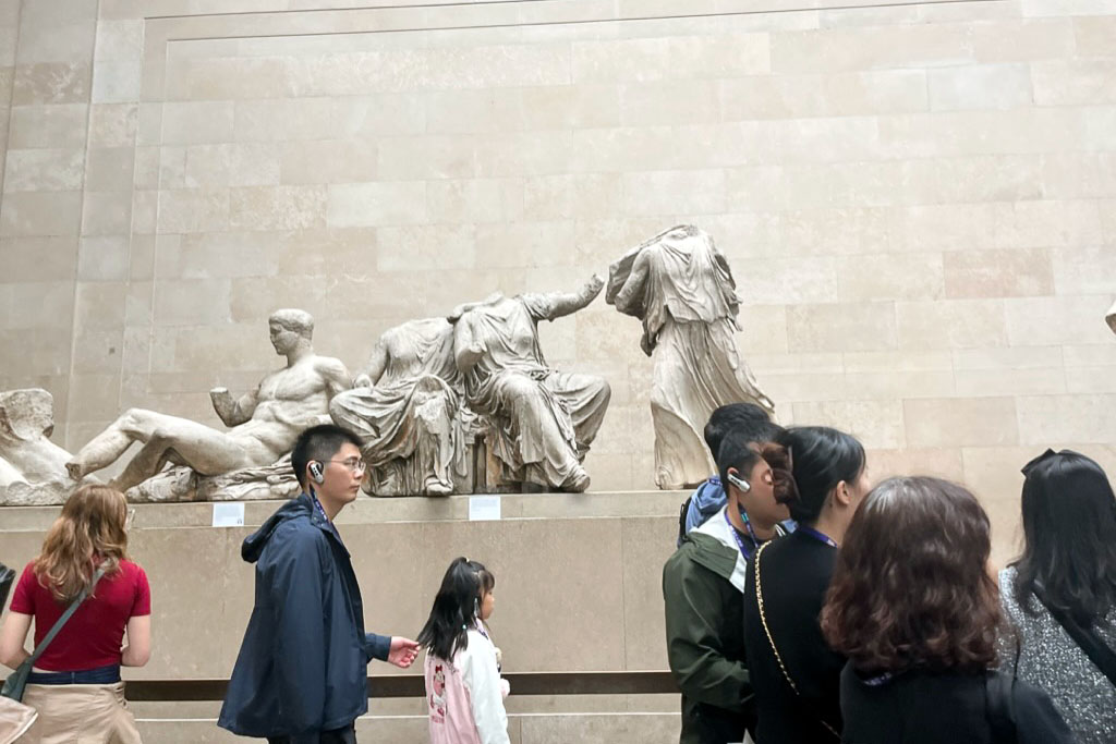 tourists walking by artifacts inside a museum