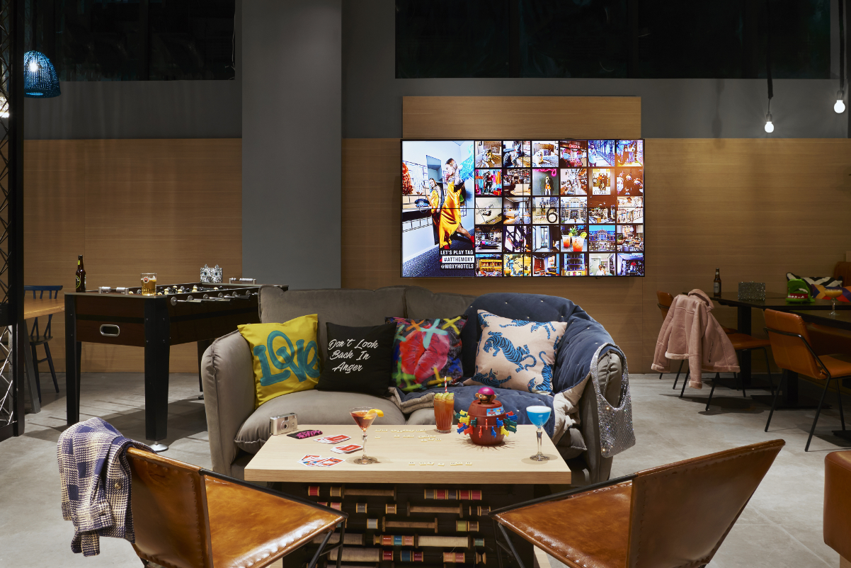 A TV screen on the wall in the bar and games area of the Moxy Manchester City hotel in Britain in 2021. Source: Marriott.