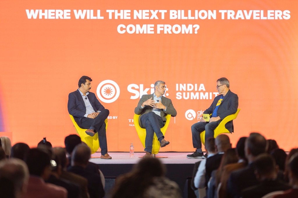 three men speaking on stage