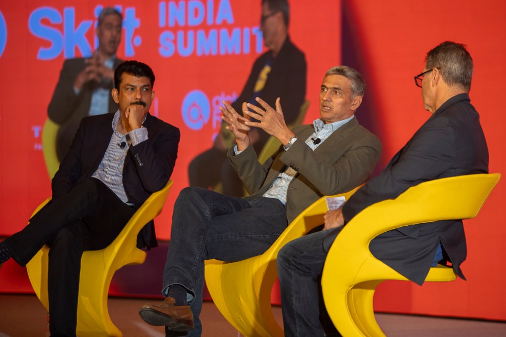 three men speaking on stage