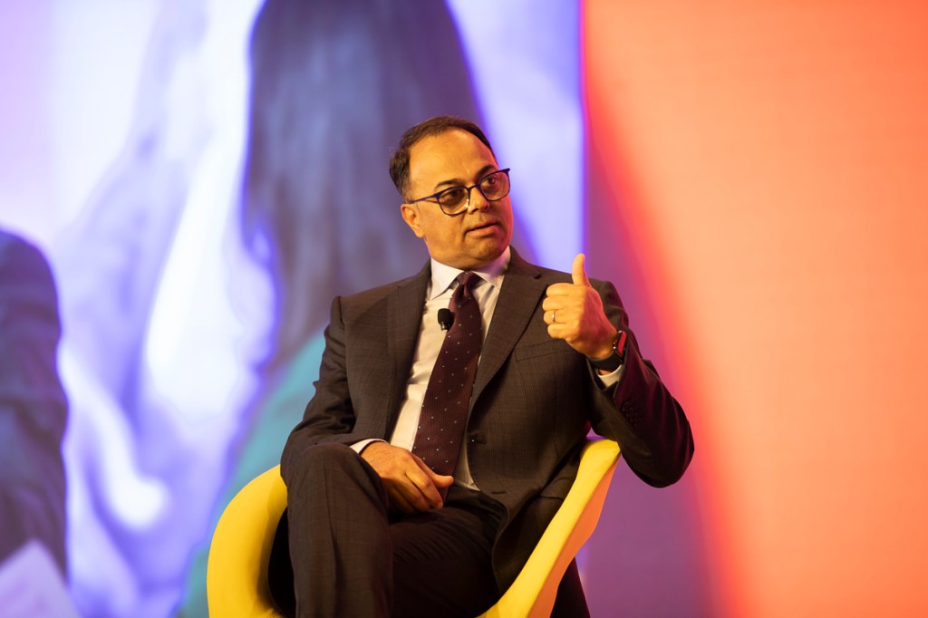 a man sitting in a yellow chair on a stage