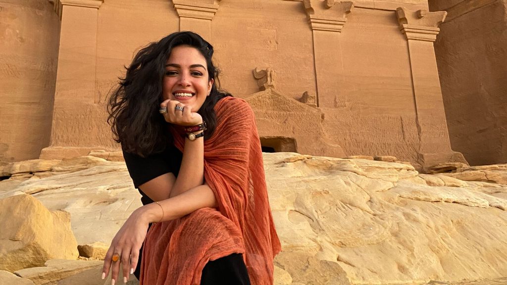 Sara Omar sitting in front of a holy Saudi site