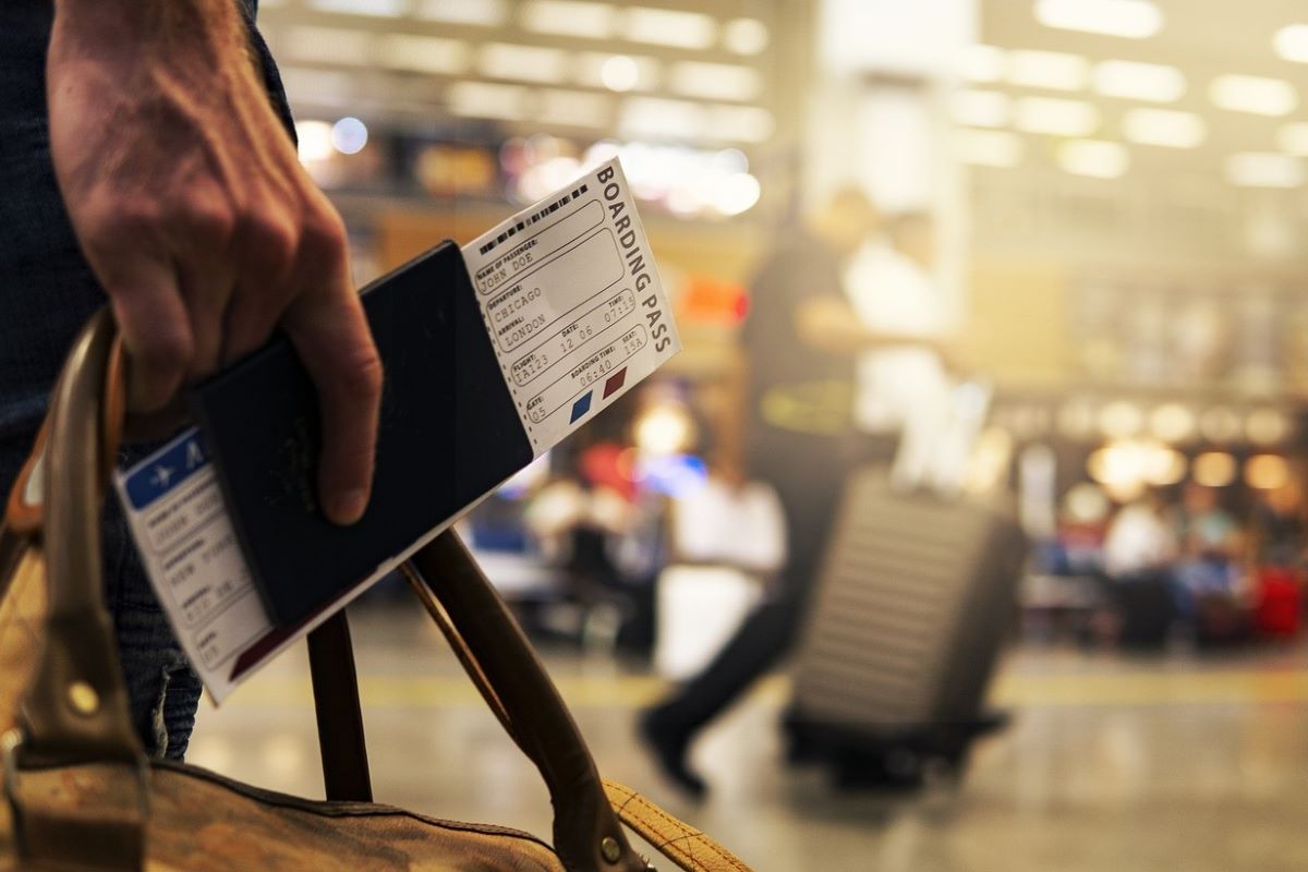 A traveler holds a boarding pass in an airport. Joshua Woroniecki/Pixabay