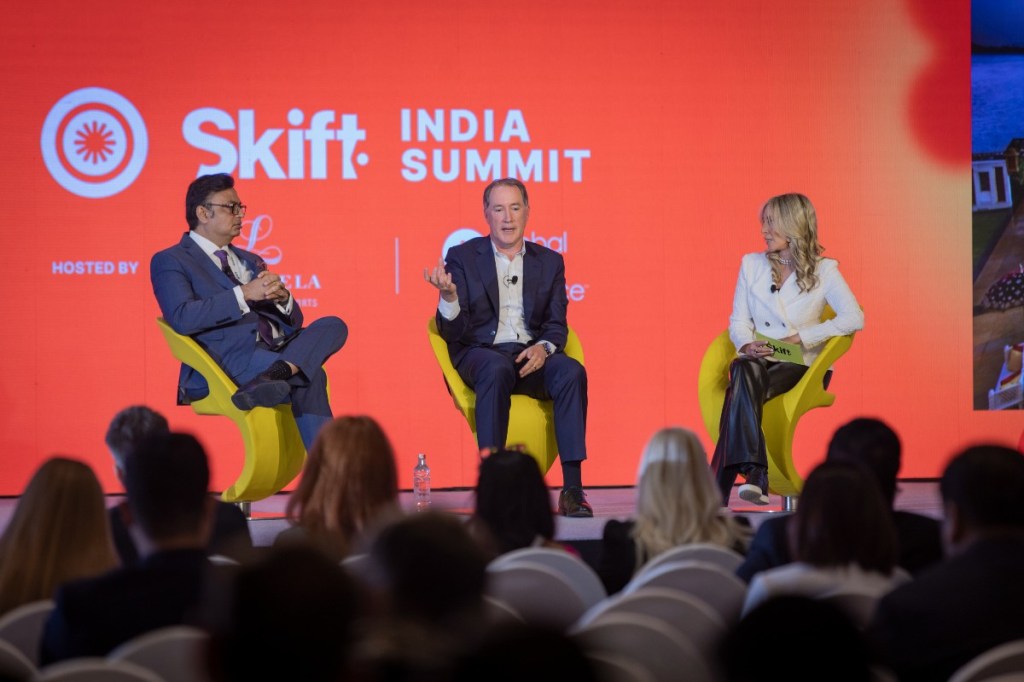 Chris Hartley and Anuraag Bhatnagar on stage with Carolyn Kremins