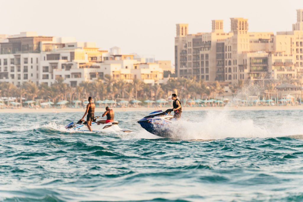 Picture of travelers on a speedboat tour with Dubai's marina in the background.