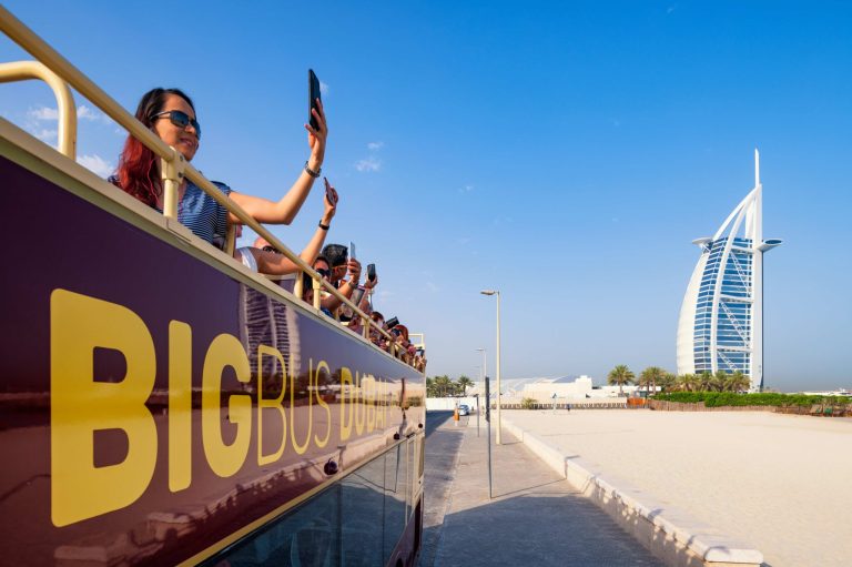Tourists taking photos during a bus tour in Dubai