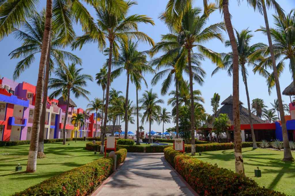 a view of a pathway to a happy tropical resort called Grand Decameron Complex Bucerías, A Trademark All Inclusive