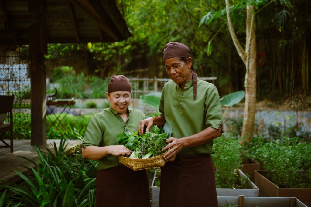 two thai workers look at fresh vegetables locally sourced for a hotel restaurant in Phuket Thailand source rosewood