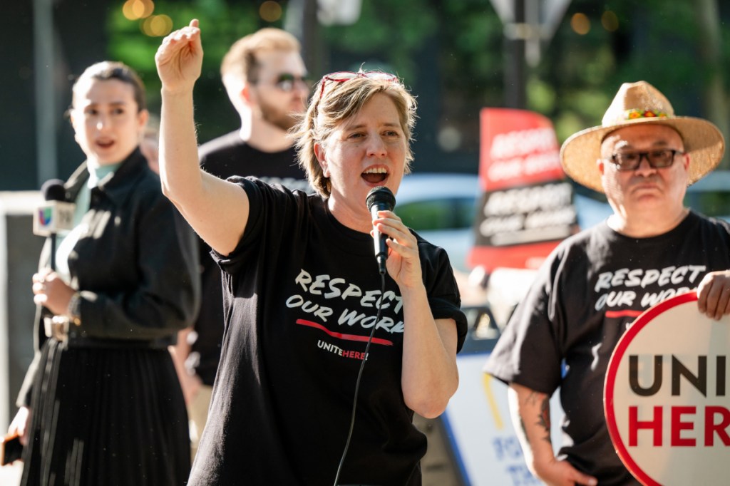 president of a labor union with arm raised among protesting hospitality workers