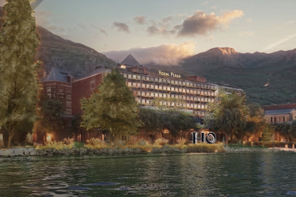 a rendering of a multi-story hotel with water in front and mountains behind.