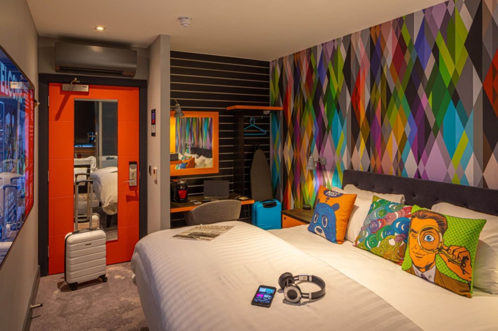 a hotel room with funky colorful decor in a tight space