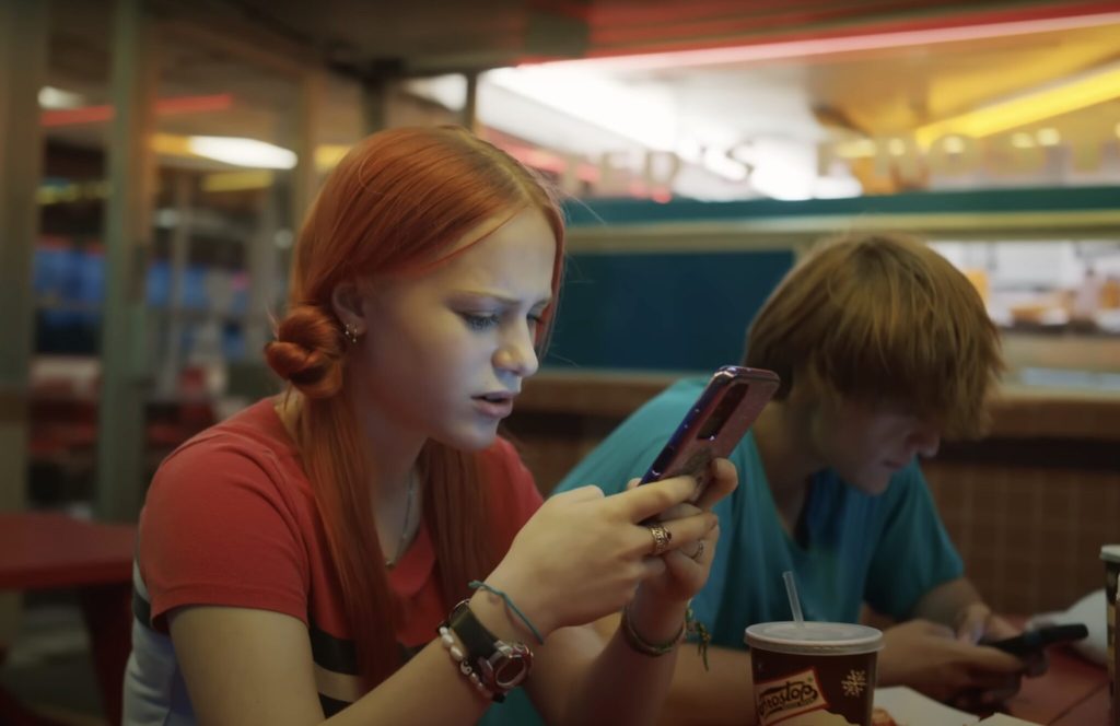 Two young people searching on their mobile phones.