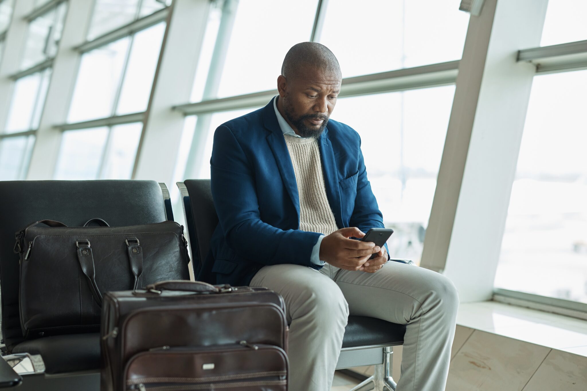 Business traveler seated at an airport gate. 