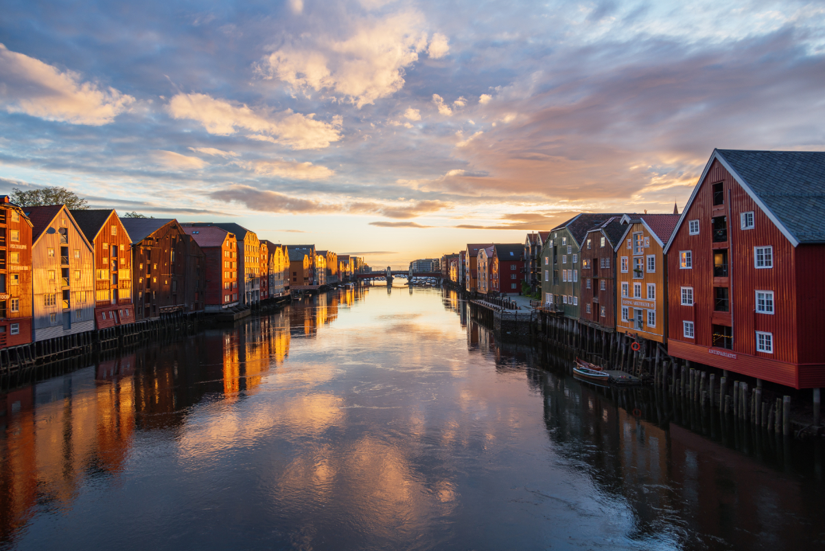 a scene of a waterway in the center of the small Norwegian town of Trondheim at dusk