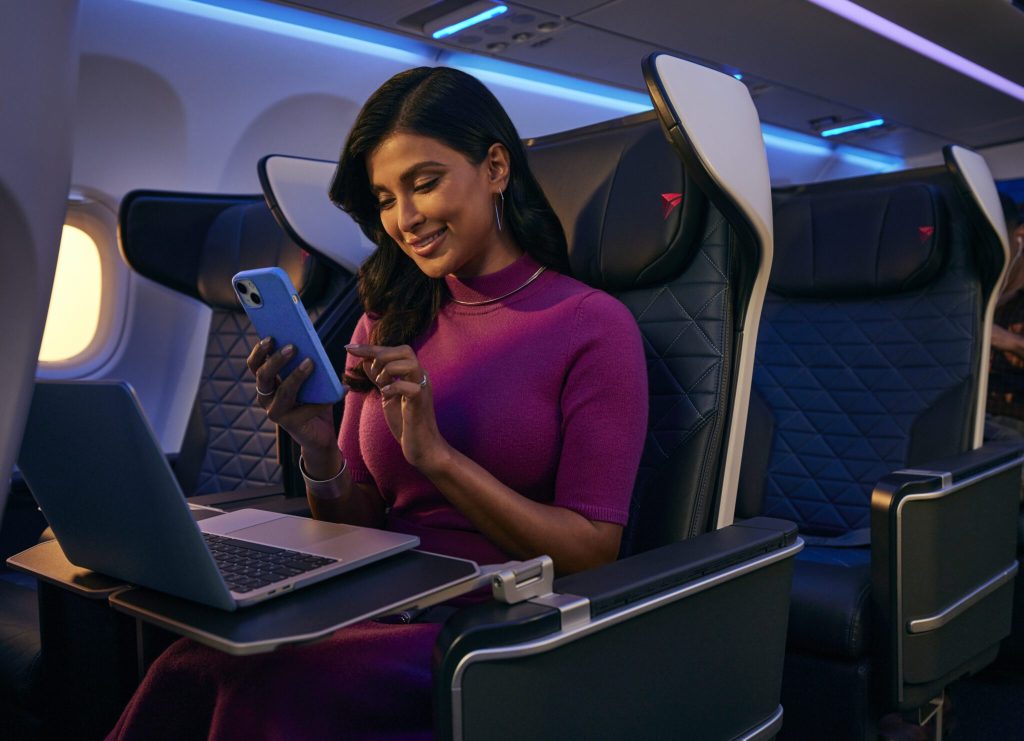 A passenger using her cell phone on a Delta plane