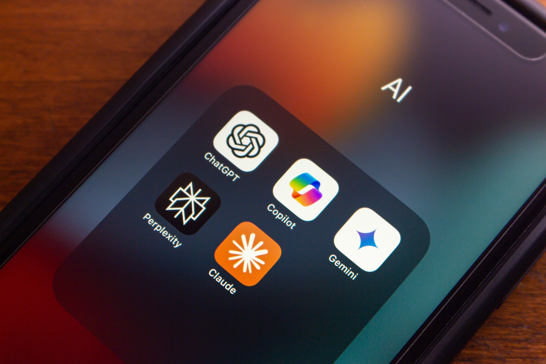 ChatGPT, Microsoft Copilot, Google Gemini, Perplexity and Claude icons seen on an iPhone. 