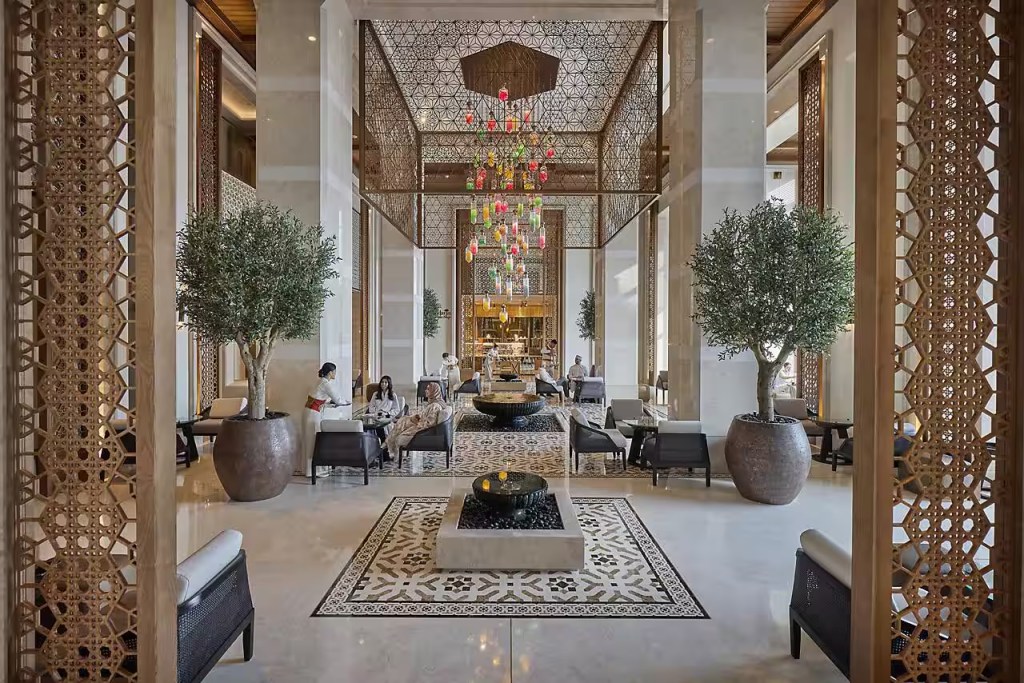 Interior of a grand hotel lobby with high ceilings and natural light