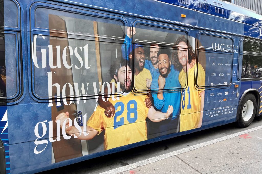 An ad for a hotel loyalty program on the side of a bus.