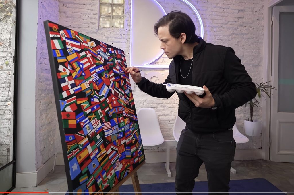 A man works on a board filled with travel magnets of different countries.