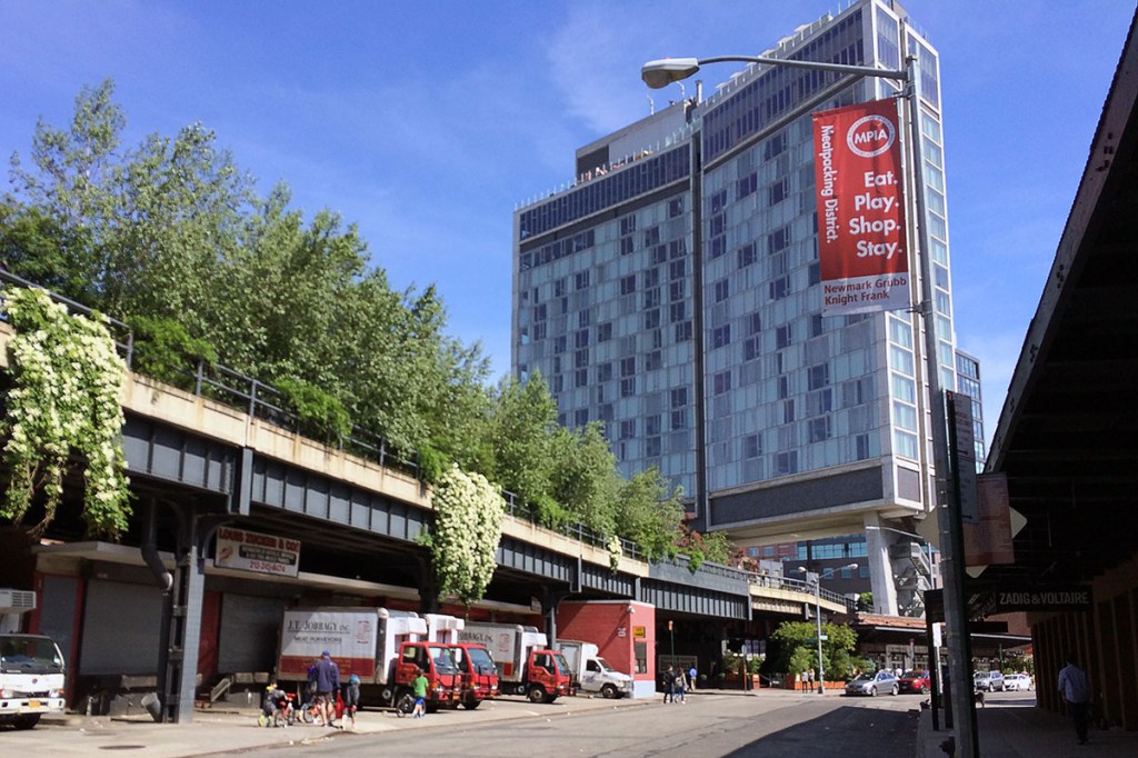 Exterior of a multi-story hotel with a raised urban park around it.