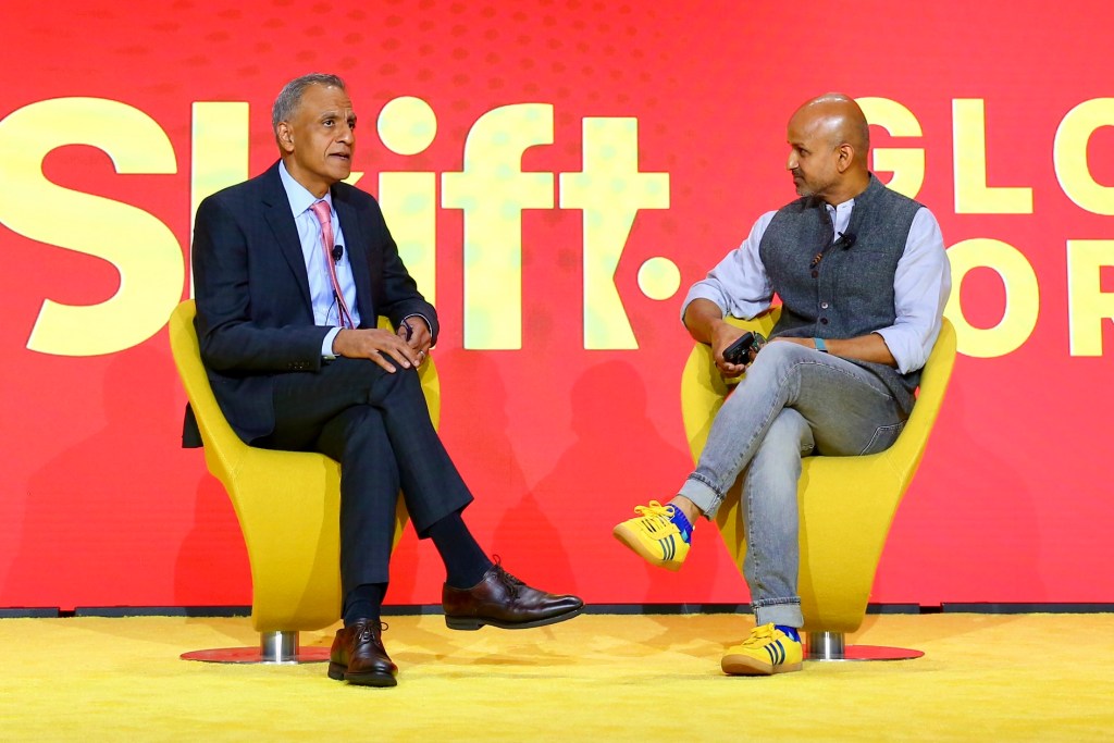 Two men in an interview session on a stage.