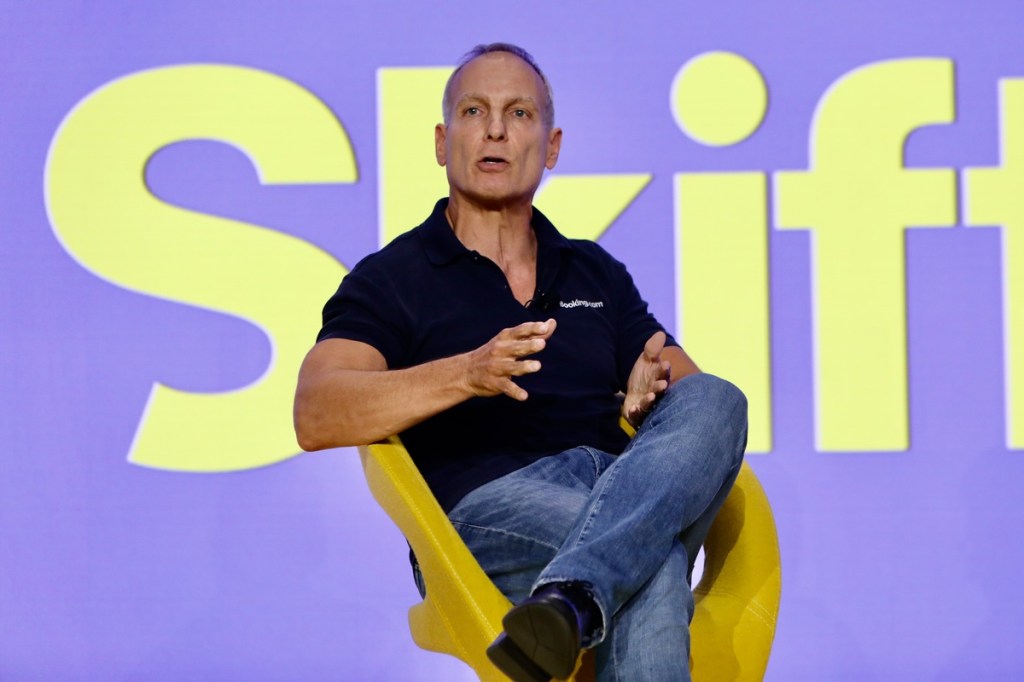 a man sitting on a yellow chair on a stage